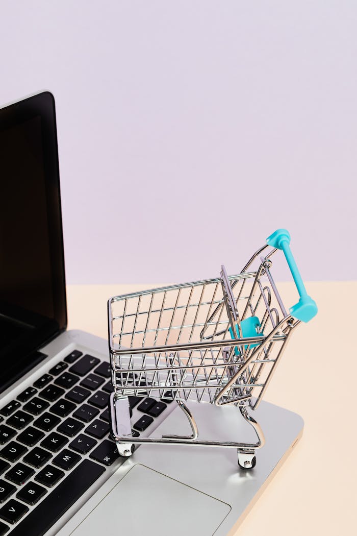 footer-cta-img Mini shopping cart on a laptop symbolizes online shopping and e-commerce themes.